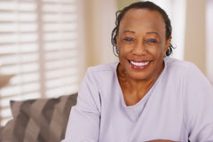 uma-mulher-negra-mais-idosa-olha-felizmente-câmera-85382495